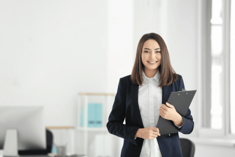 Woman Lawyer standing in front of desk holding a clipboard